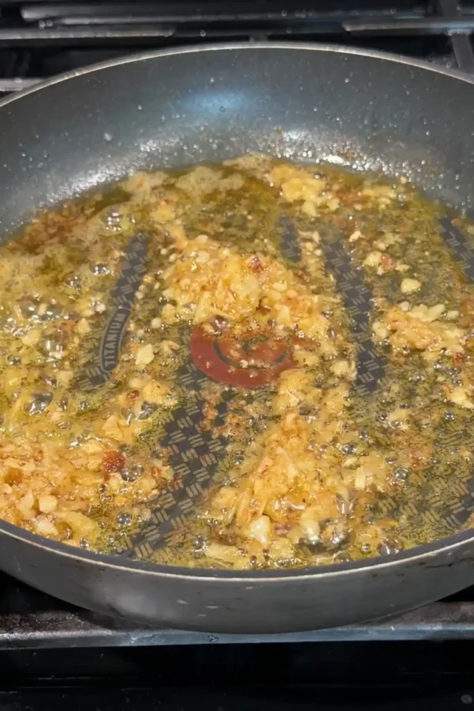 Roasted garlic sautéing in the skillet, spread across the pan and turning fragrant and golden in the butter and oil mixture.
