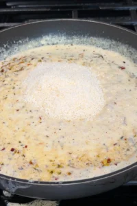 Creamy garlic sauce topped with grated parmesan in a pan