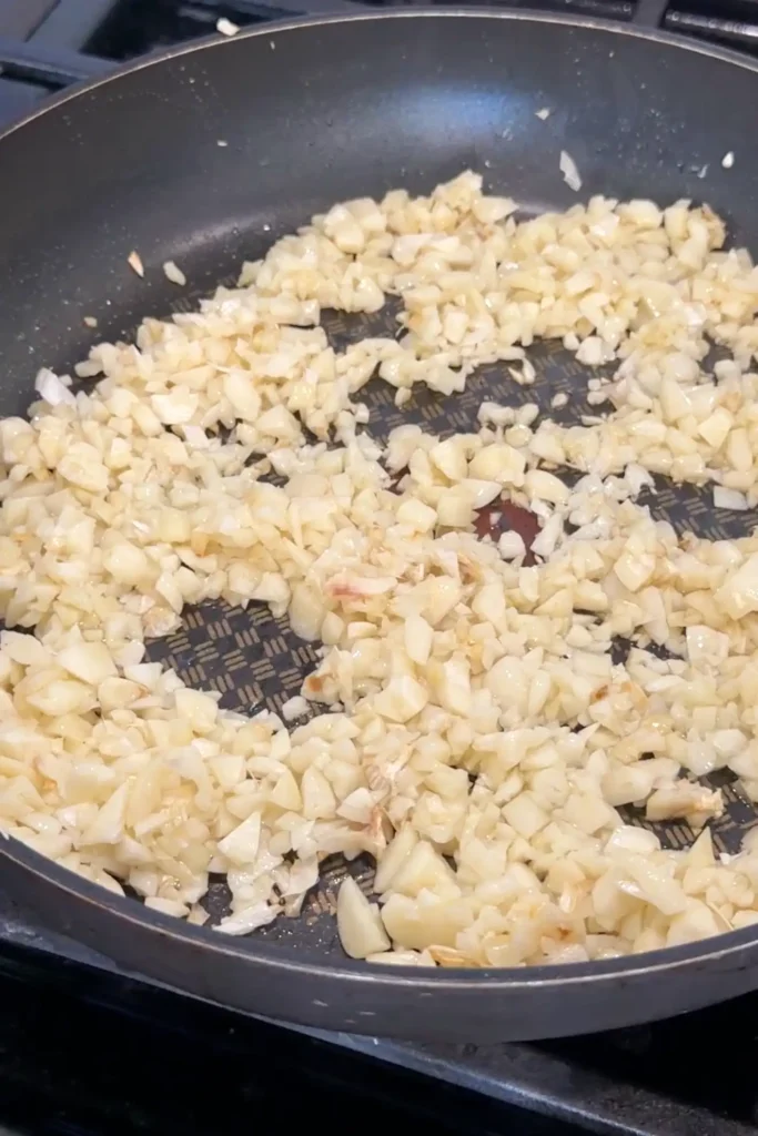 a large nonstick skillet filled with freshly minced garlic cooking in oil on the stovetop.