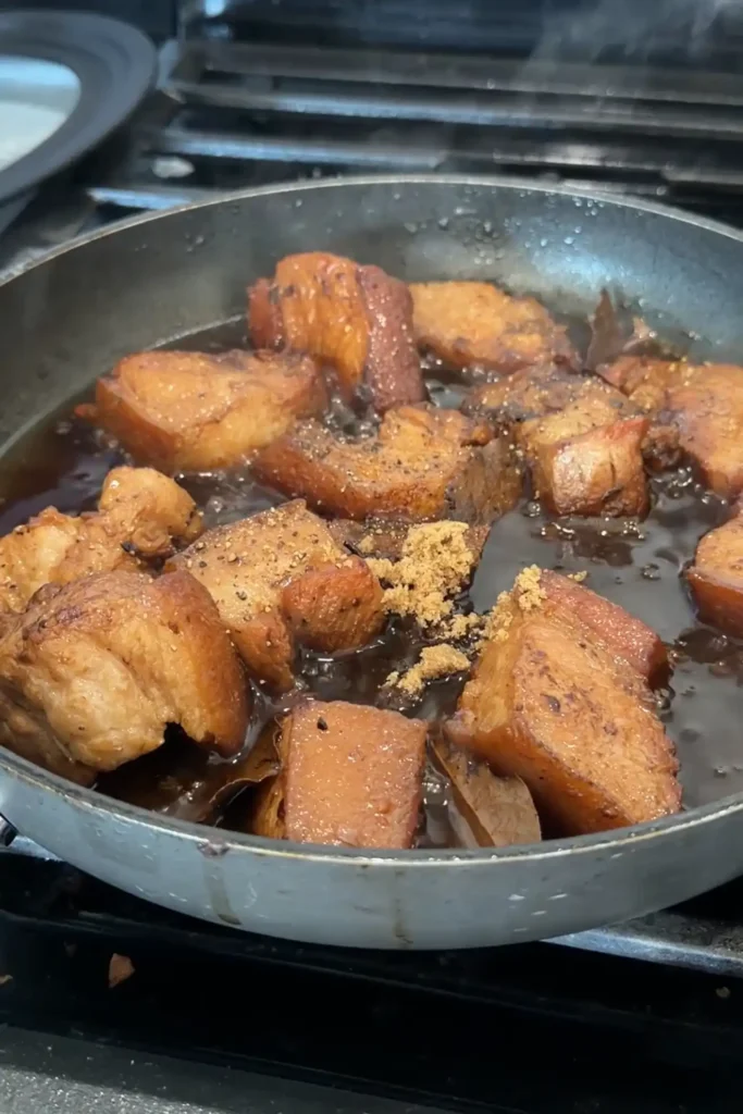 A small mound of brown sugar and a sprinkle of black pepper added to the adobo.