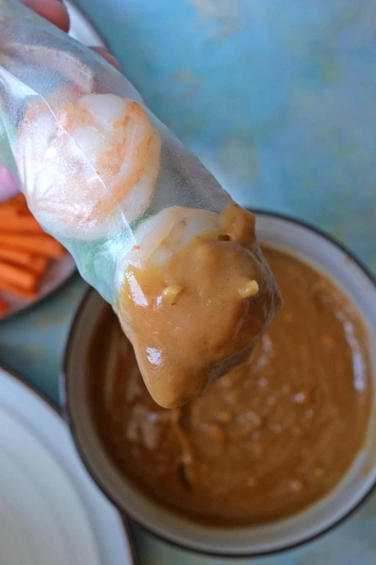 Vietnamese fresh spring roll dipped in creamy peanut sauce close-up