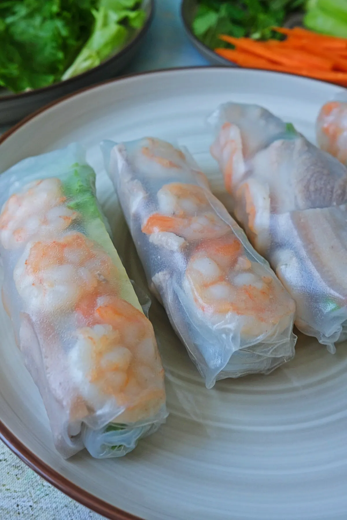 Close-up of Vietnamese spring rolls showing shrimp, pork, and fresh vegetables inside rice paper
