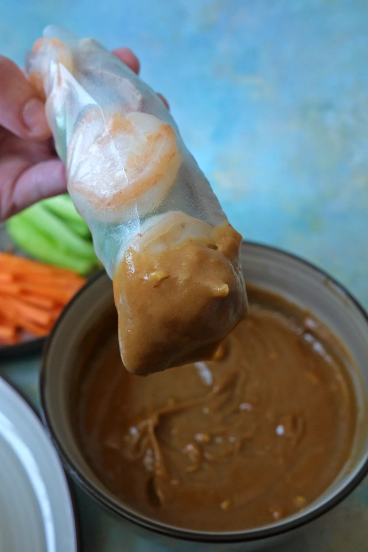 Fresh shrimp and pork spring rolls on a plate with visible herbs and lettuce
