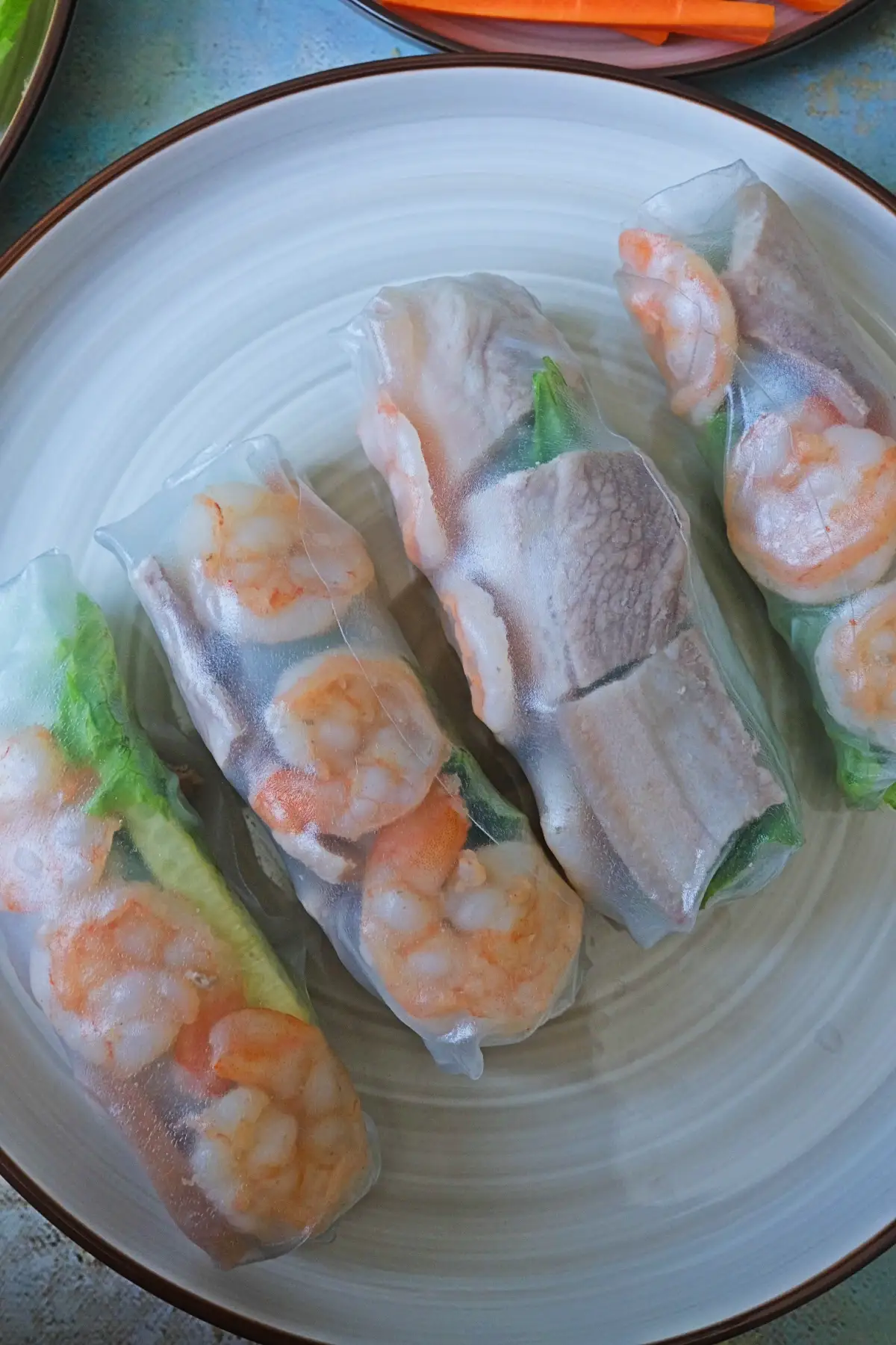 Overhead view of Vietnamese spring rolls with peanut sauce and fresh greens