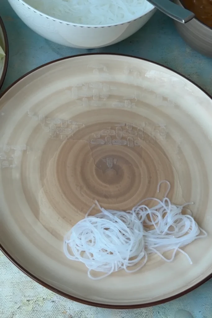 Small portion of cooked rice noodles placed on a plate for assembling spring rolls