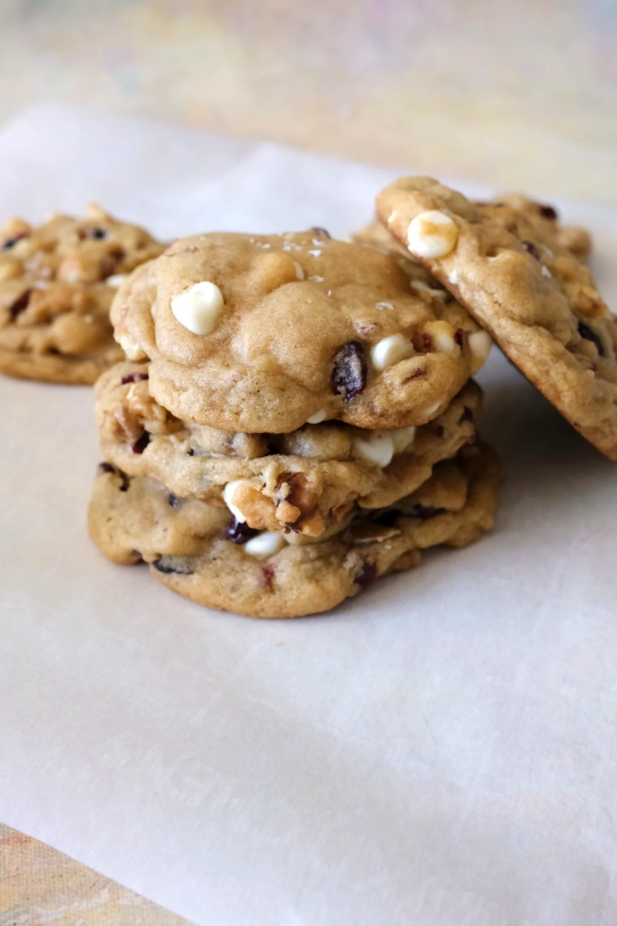Stack of soft and chewy cranberry white chocolate cookies with walnuts and white chocolate chips, showing golden edges and tender centers.