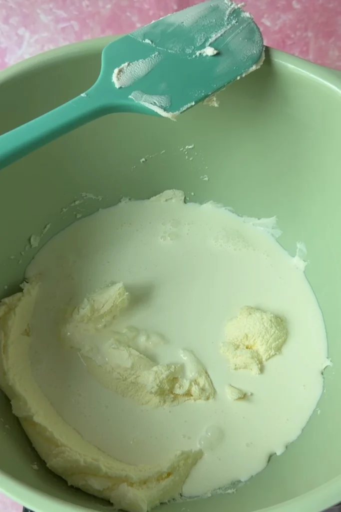 Heavy cream and mascarpone cheese in a mixing bowl before whipping into chantilly frosting.
