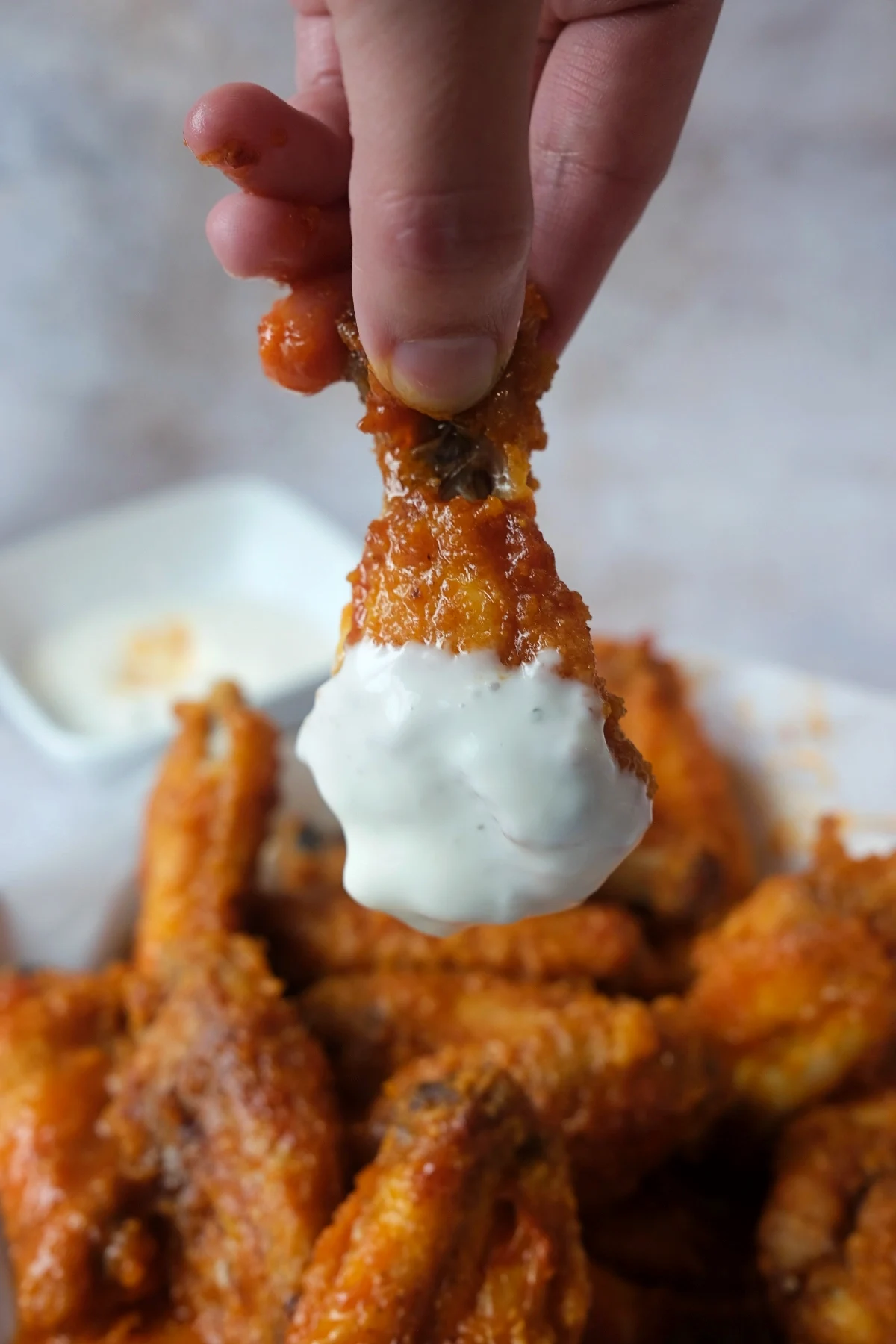 Crispy homemade buffalo wings topped with ranch dressing and coated in a buttery spicy buffalo sauce