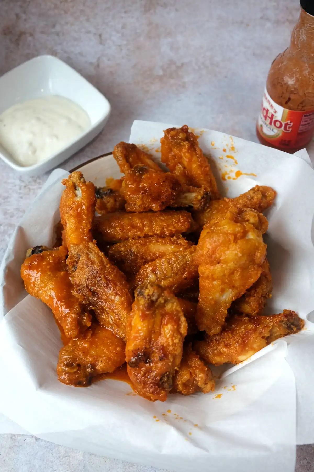 Homemade buffalo chicken wings with a crispy golden coating, spicy buttery sauce, and ranch dressing on the side.