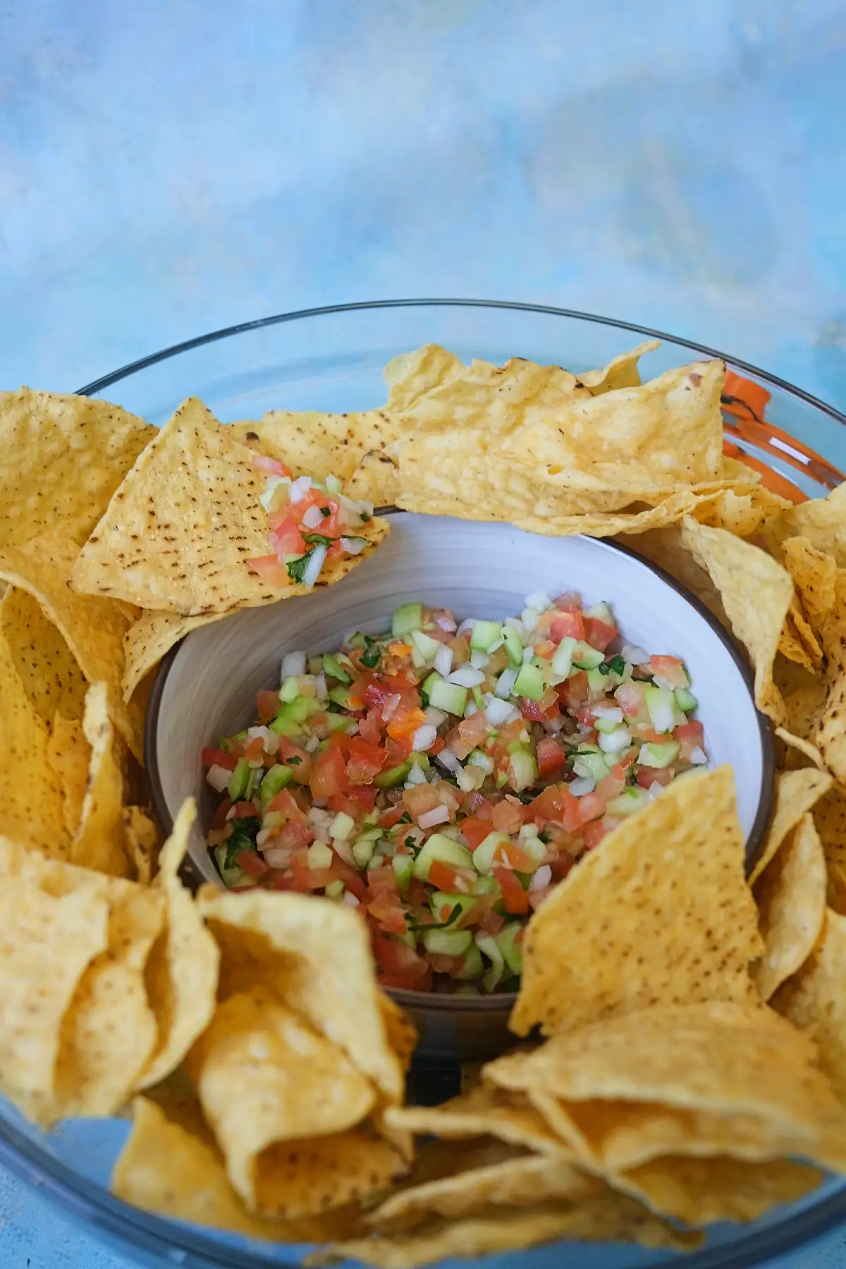 Bowl of fresh chunky salsa surrounded by crispy tortilla chips.