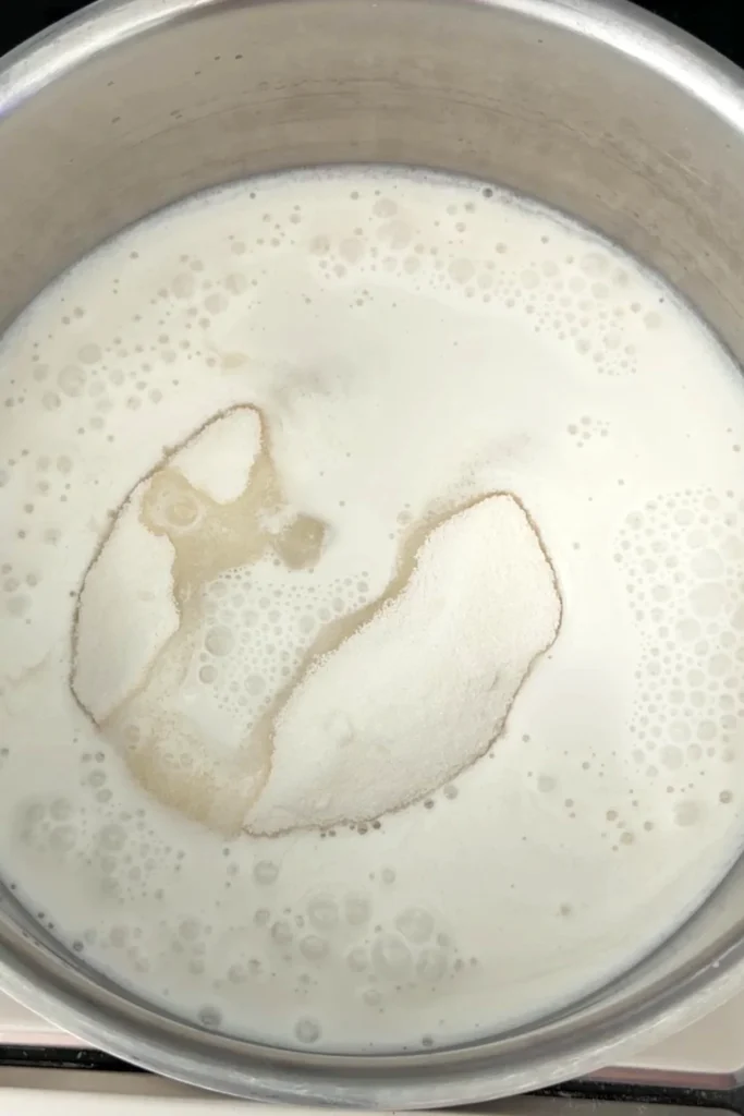 Coconut milk and sugar added to a saucepan to make the sweet coconut mixture for sticky rice.