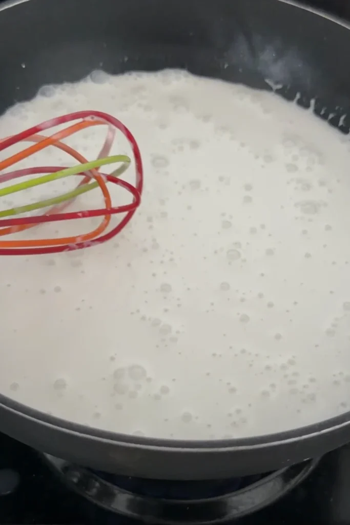 Whisking coconut milk and corsntarch over low heat