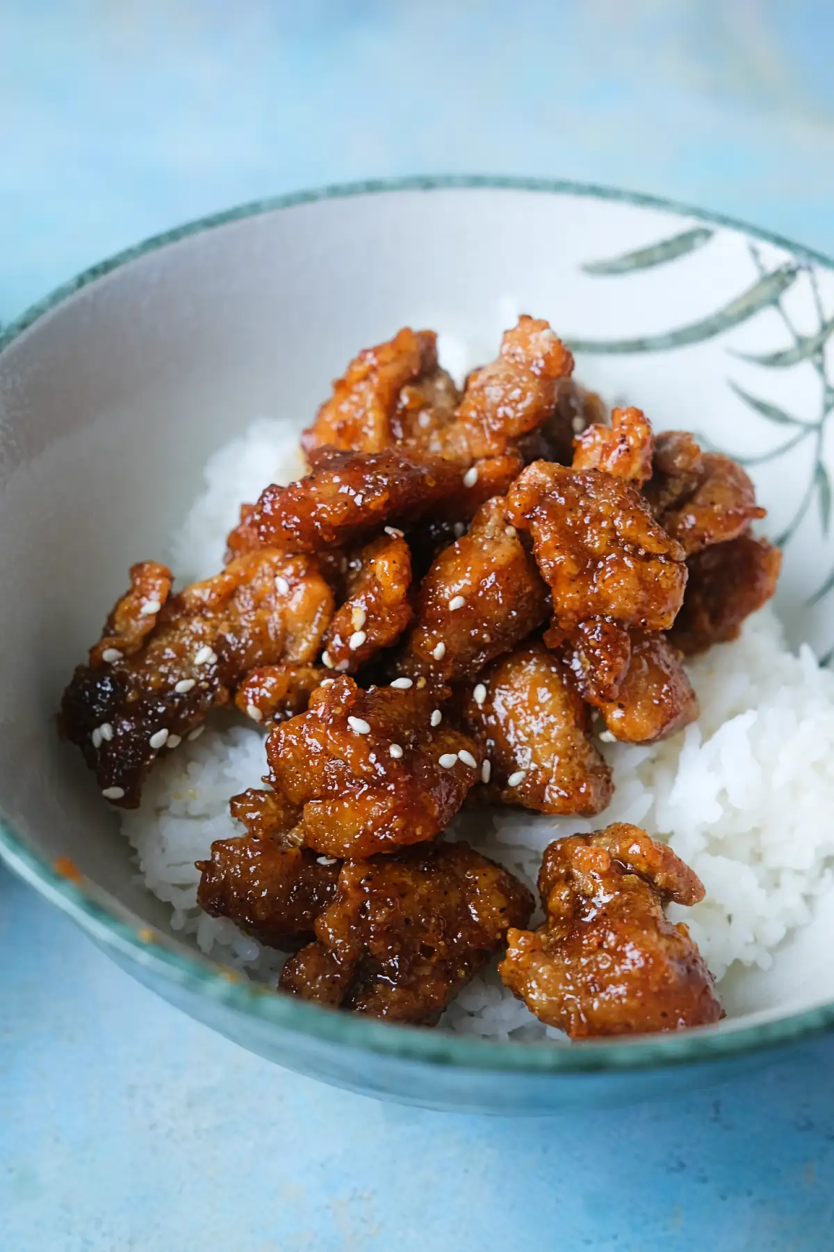 Bowl of sticky honey garlic chicken over steamed white rice.