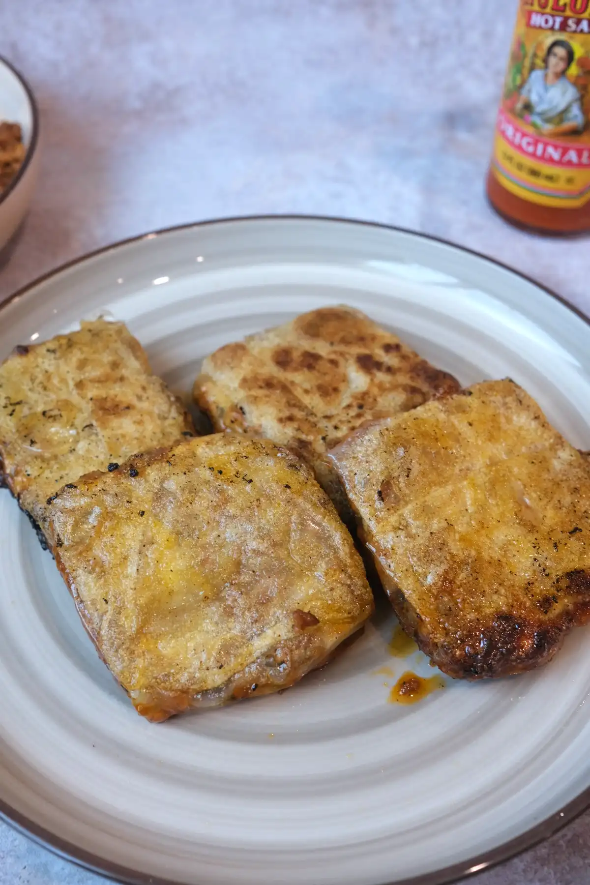 Golden brown crispy rice paper wraps with cheesy pork filling served on a plate.