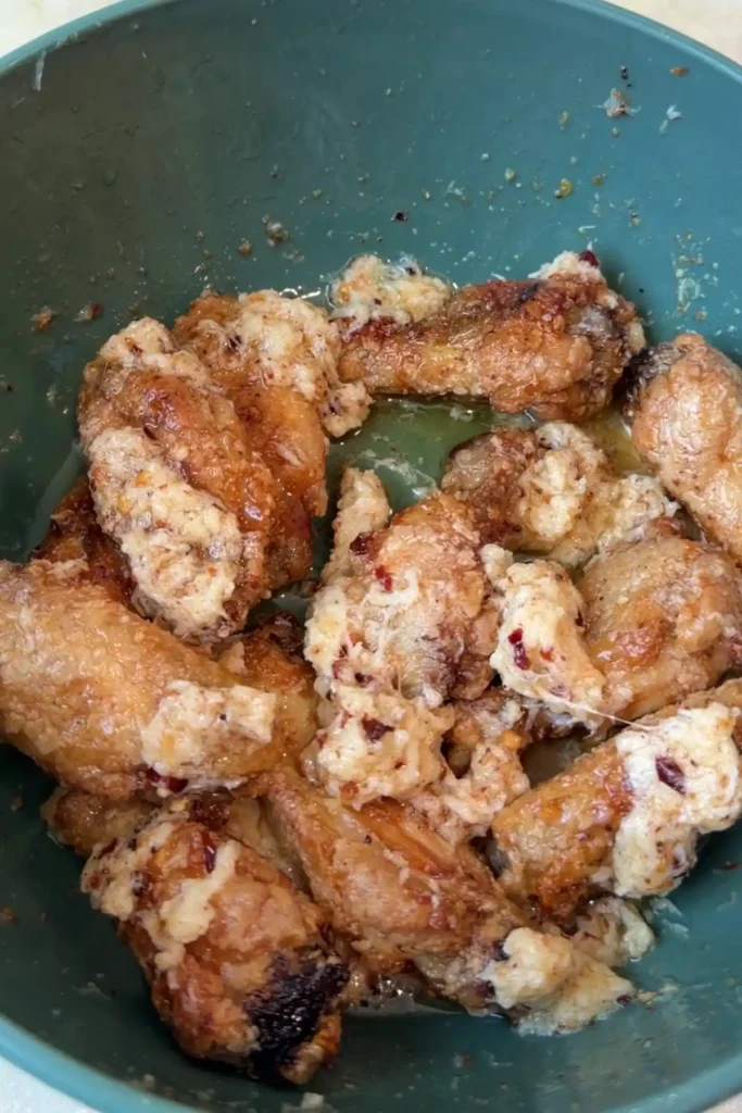 Air fryer garlic parmesan wings tossed in creamy buttery parmesan sauce with chili flakes.