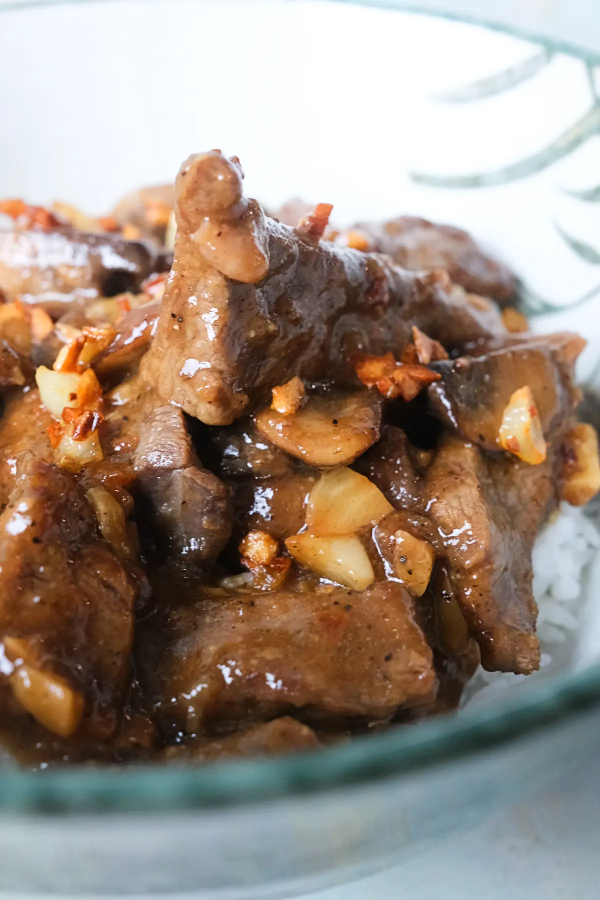 Spoonful of mushroom pepper steak over rice with tender beef and rich garlic pepper gravy.
