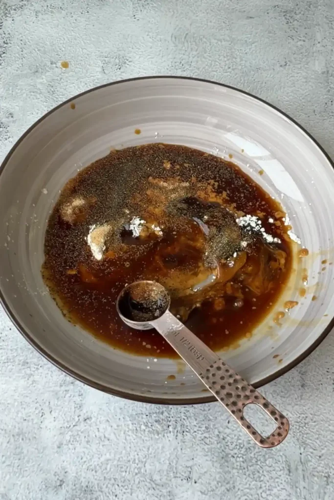 Brown sauce mixture with soy sauce, oyster sauce, black pepper, cornstarch, and seasonings in a bowl before mixing.