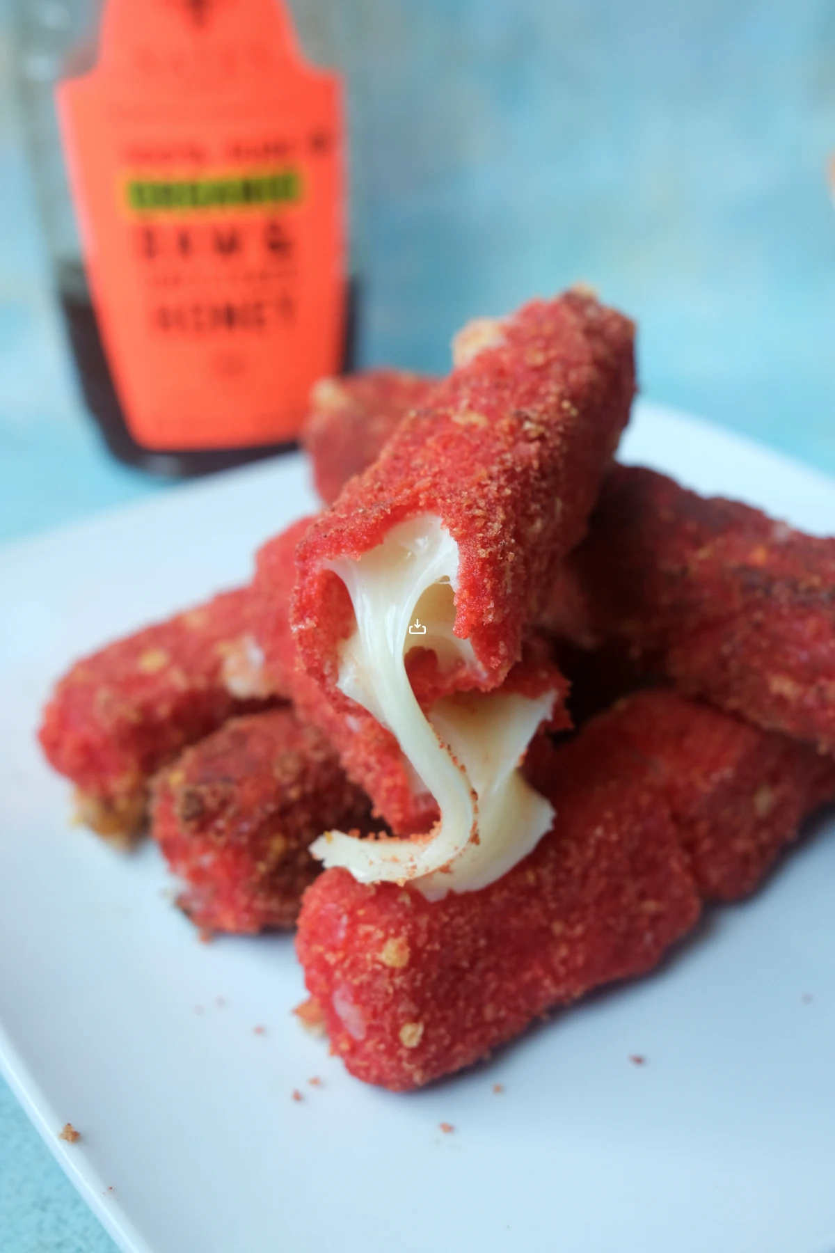 Gooey mozzarella cheese pull inside crispy Hot Cheetos-coated mozzarella sticks.