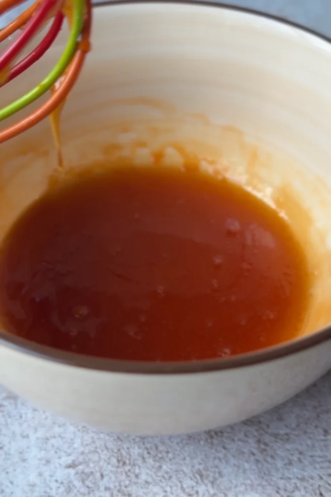 Close-up of homemade hot honey sauce with chili oil mixed into honey.