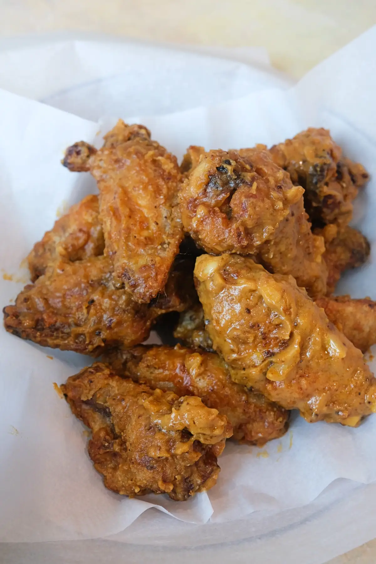 Close-up of crispy Filipino-inspired kare kare chicken wings tossed in a rich peanut butter sauce.