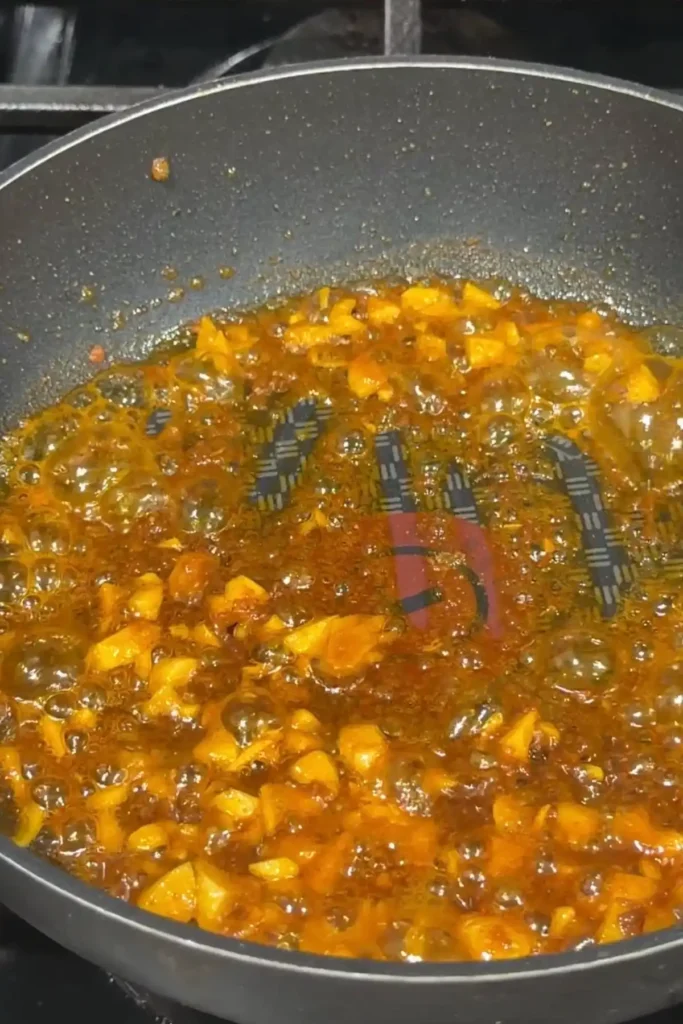Garlic sizzling in annatto oil while cooking the base for kare kare sauce.