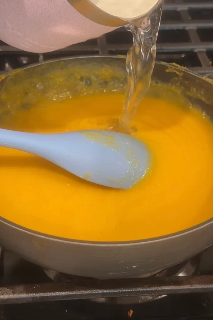 Water poured into mango habanero sauce to loosen the consistency.