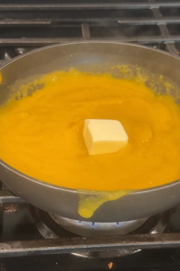 Butter added to warm mango habanero sauce in a saucepan.
