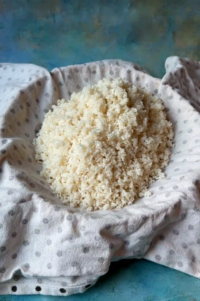 Glutinous rice in a cloth-lined steamer basket.