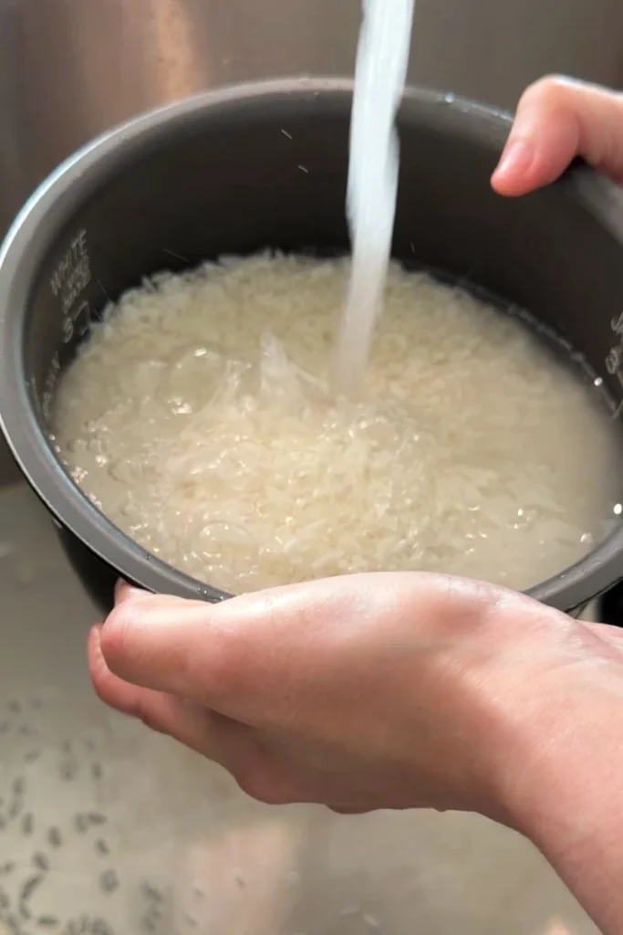 Rinsing glutinous rice under cold running water until the water runs clearer.