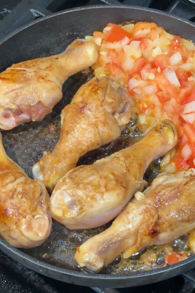 Chicken drumsticks lightly seared before simmering in tomato sauce for afritada