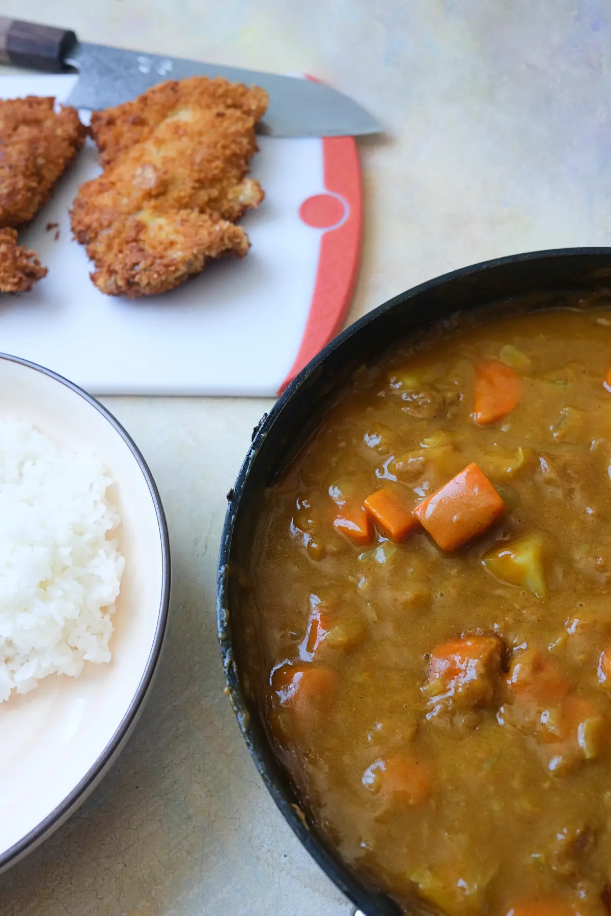 Homemade Japanese chicken katsu curry ingredients with rice, curry sauce, and fried chicken.