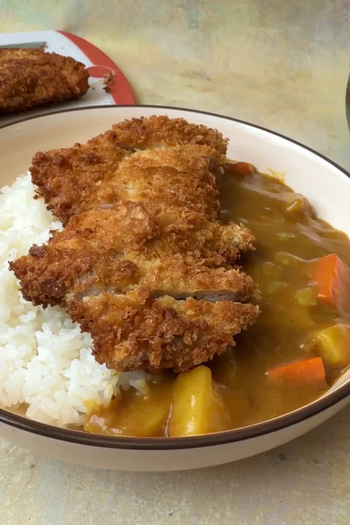 Chicken katsu curry with crispy fried chicken, steamed rice, potatoes, carrots, and rich Japanese curry sauce.