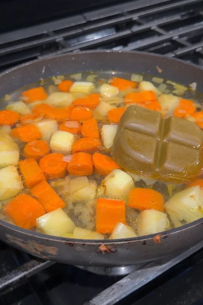 Japanese curry roux cube added to simmering vegetables and broth.