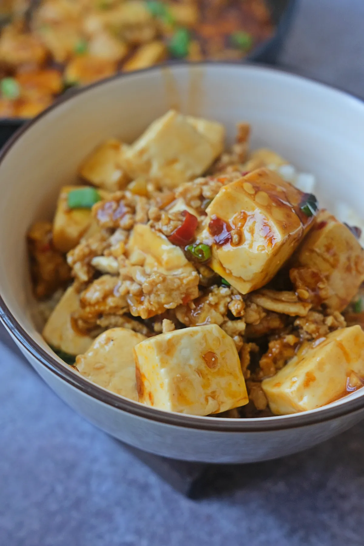 Close-up rice bowl with chicken mapo tofu served over steamed white rice.