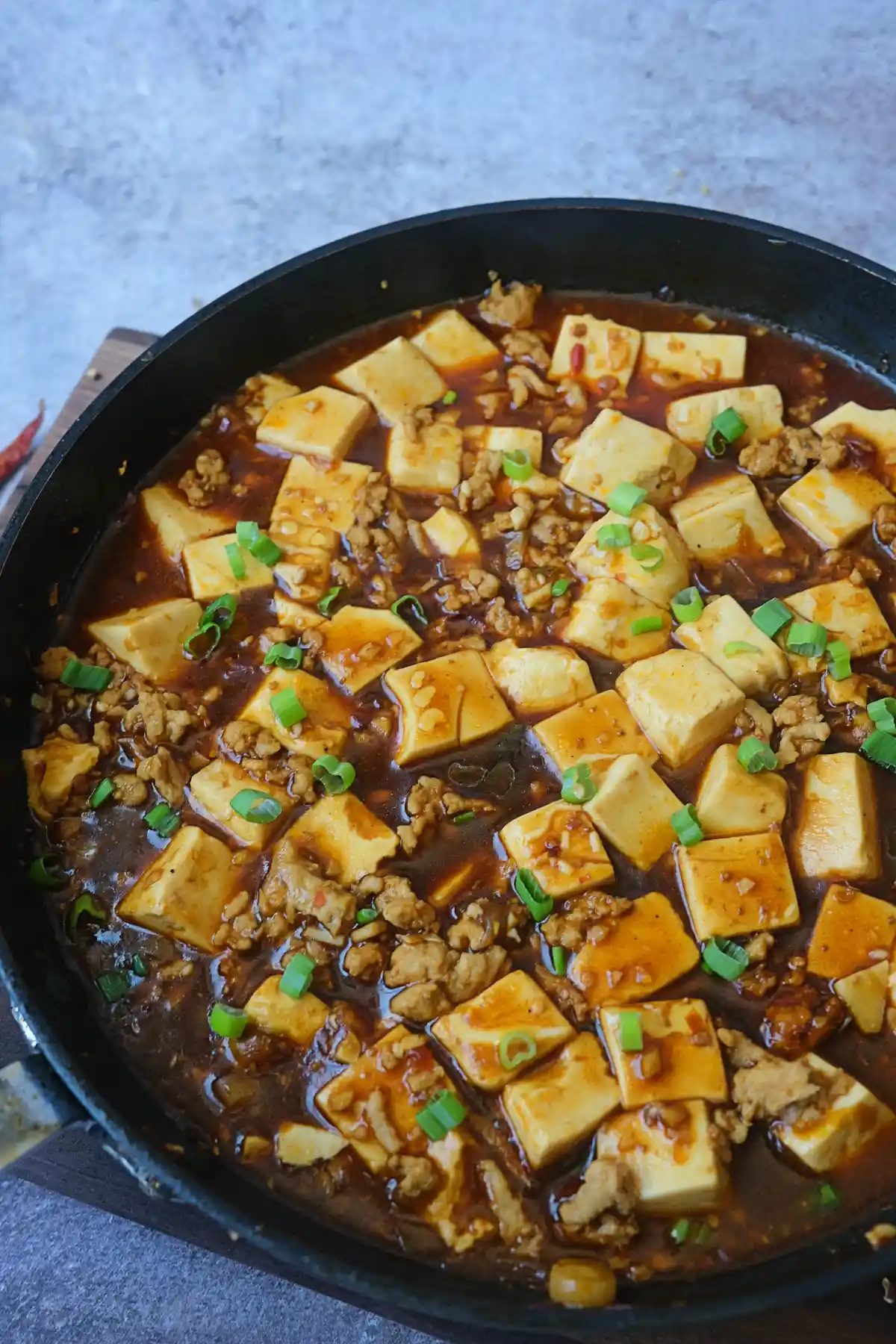 Homemade chicken mapo tofu with silken tofu, ground chicken, and green onion garnish.