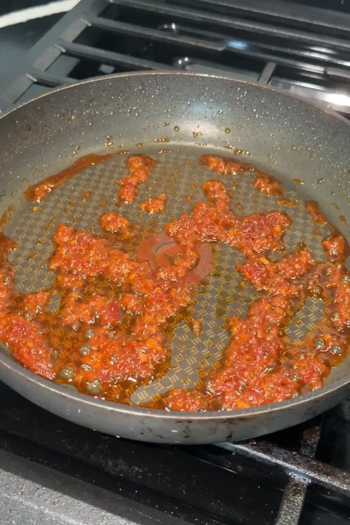 Doubanjiang cooking in oil until fragrant and deep red for chicken mapo tofu.