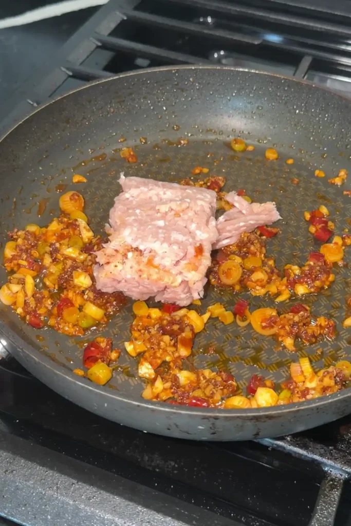 Ground chicken added to aromatics and doubanjiang mixture for chicken mapo tofu.