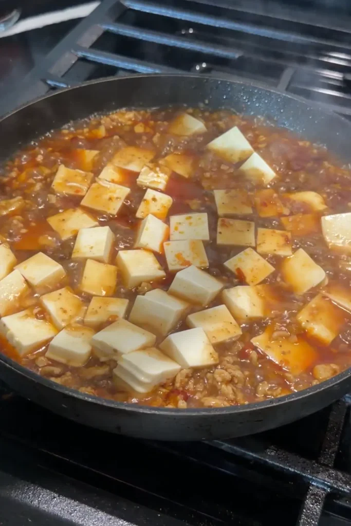 Silken tofu simmering in a spicy Sichuan-style sauce with ground chicken.