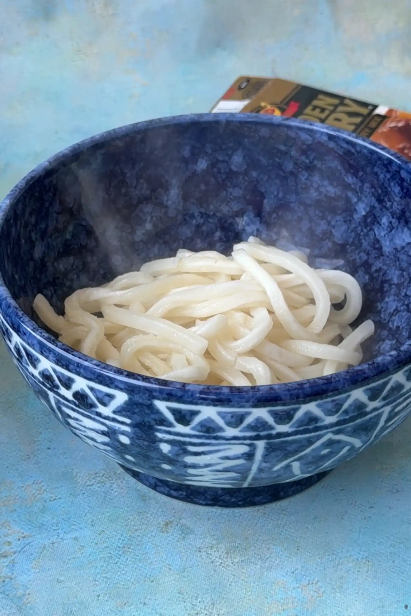 Cooked udon noodles added to a serving bowl for Japanese Curry Udon