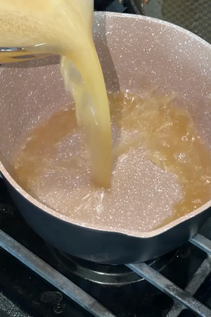 Pouring dashi broth into a pot for Japanese Curry Udon
