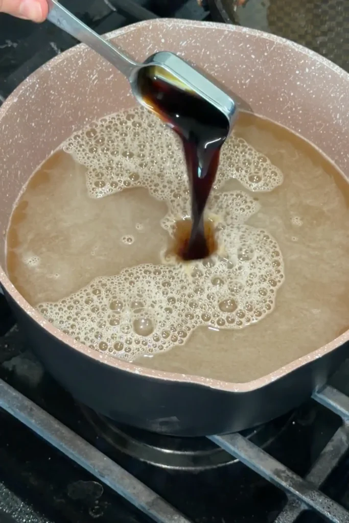 Adding soy sauce to the dashi broth for Japanese Curry Udon