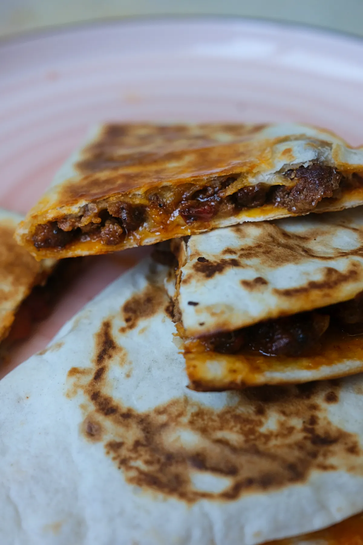 Close-up of crispy ground beef quesadillas with melted cheese and flavorful beef filling.