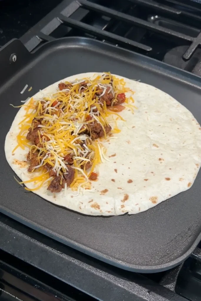 Extra shredded cheese added over the beef filling before folding the quesadilla.
