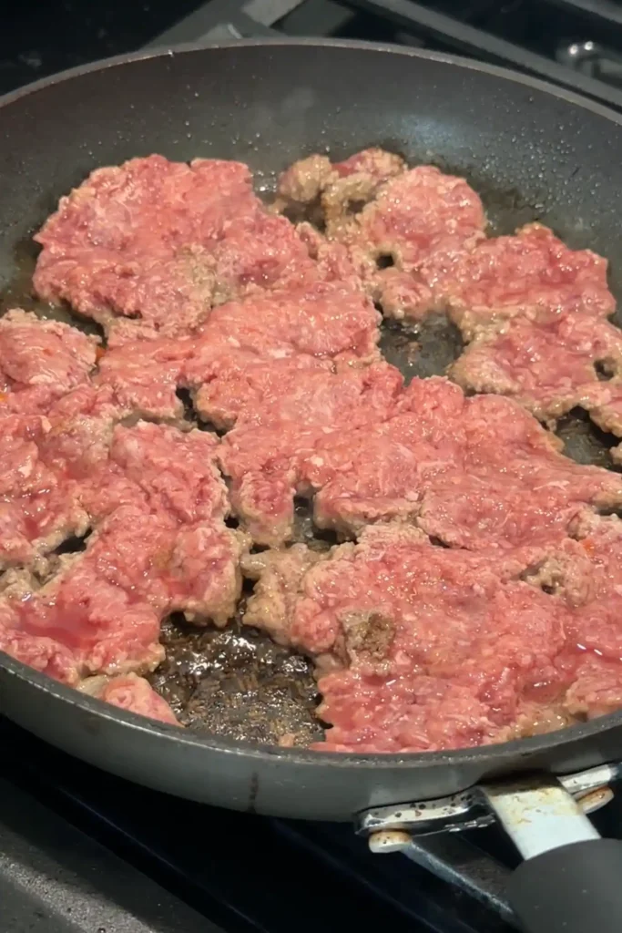 Ground beef cooking in a skillet.