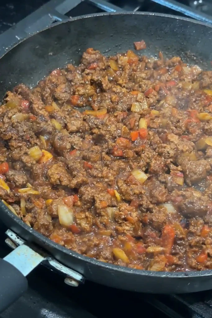 Seasoned ground beef filling simmering in a skillet.