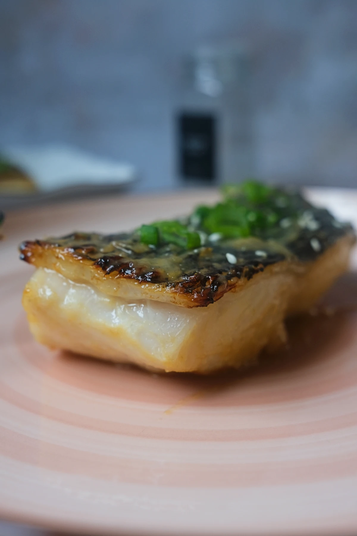 Miso glazed Chilean sea bass topped with green onions and sesame seeds