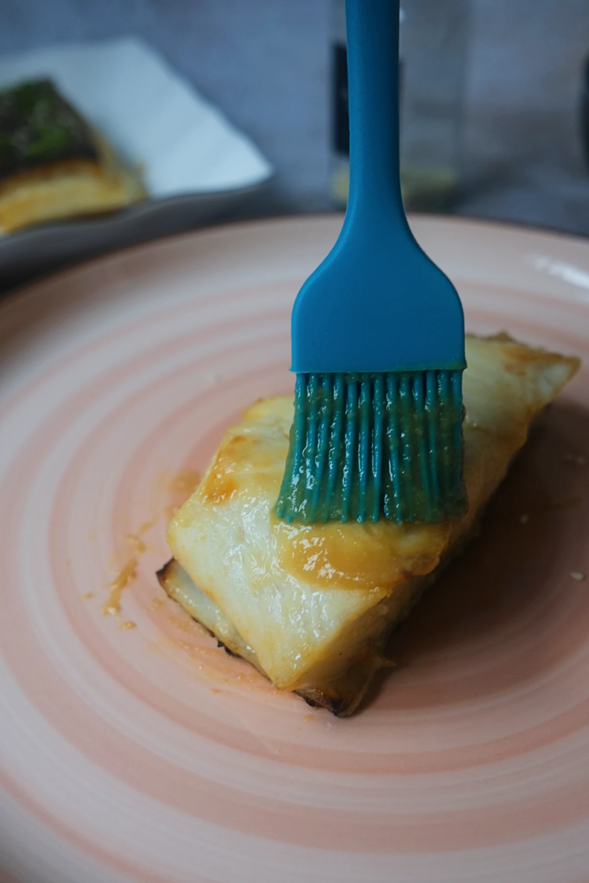 Brushing cooked Chilean sea bass with homemade miso glaze
