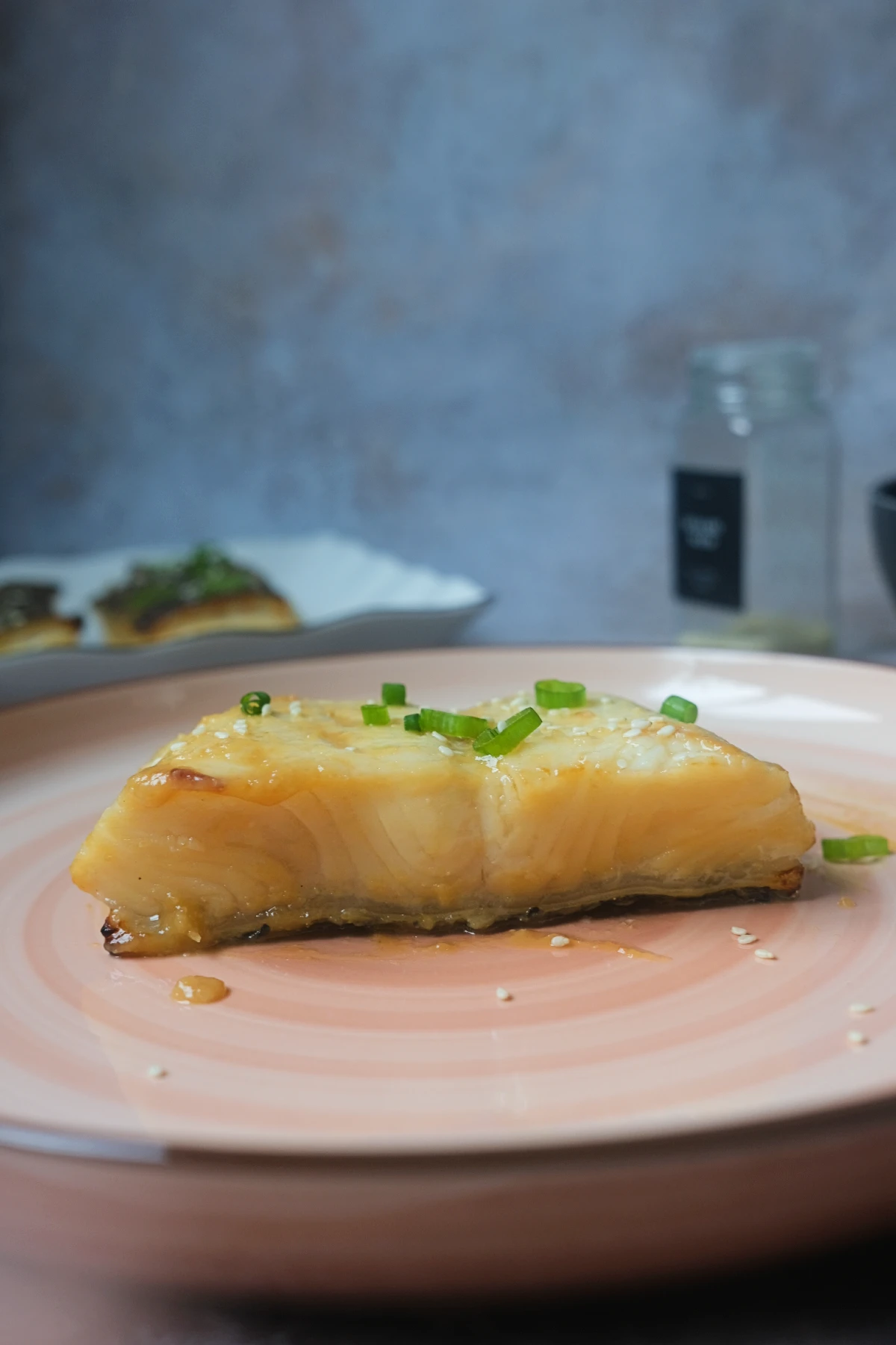 Buttery miso glazed Chilean sea bass served on a pink plate
