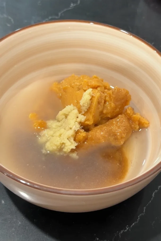 White miso paste, mirin, soy sauce, brown sugar, and ginger in a bowl