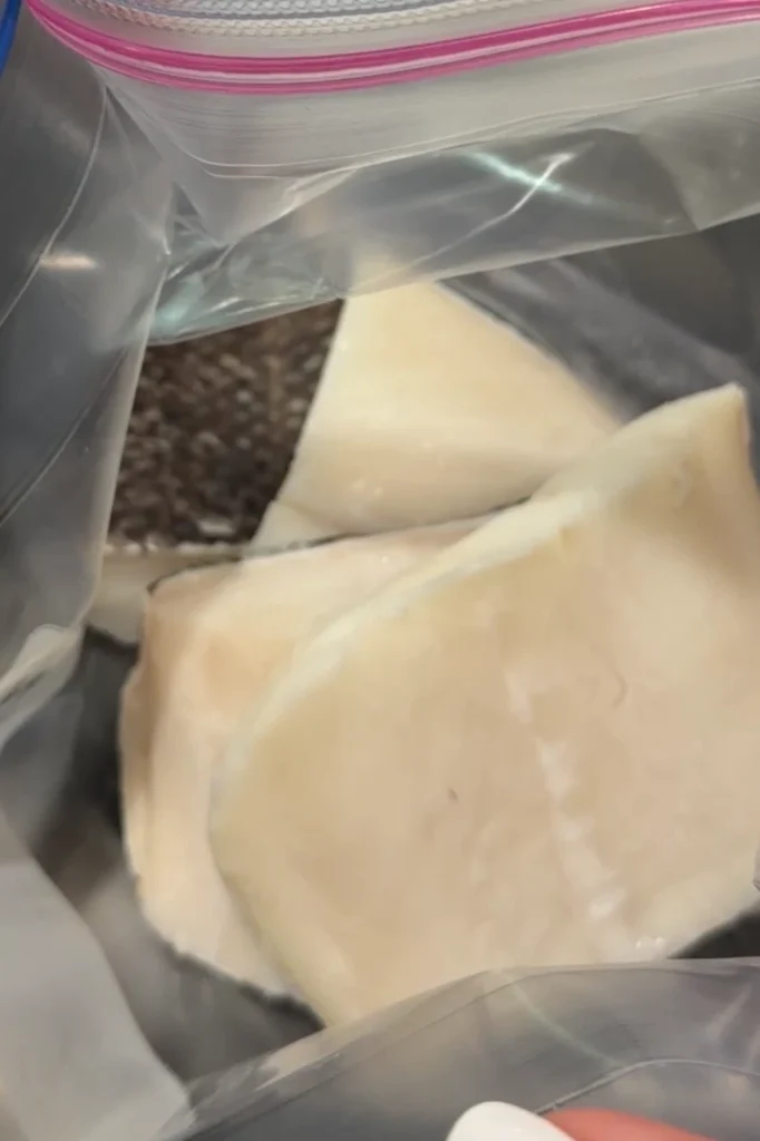 Raw Chilean sea bass fillets in a zip-top bag